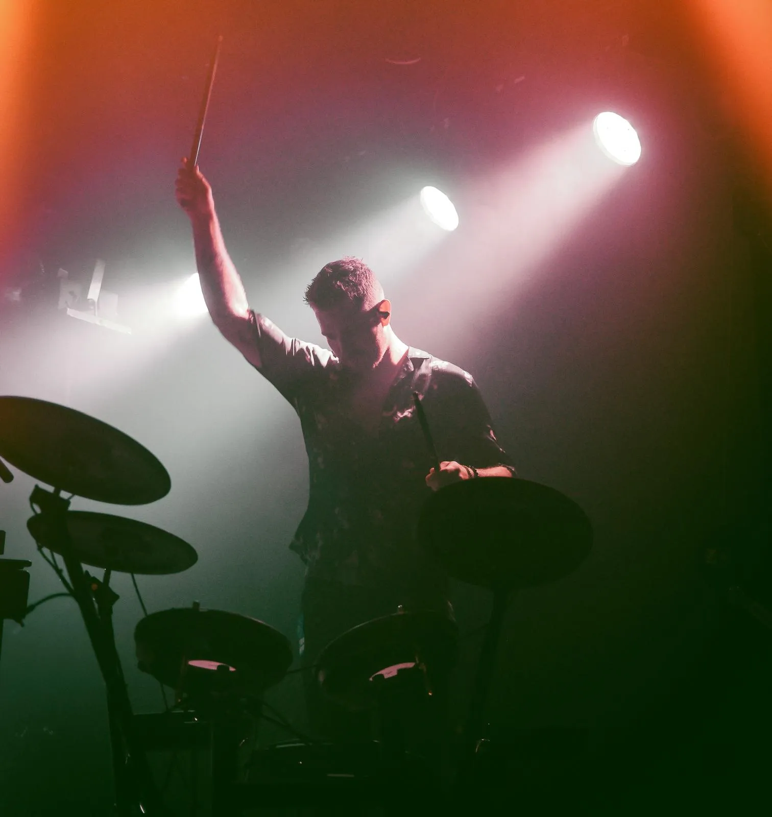 Jakke playing electronic drums under stage lights